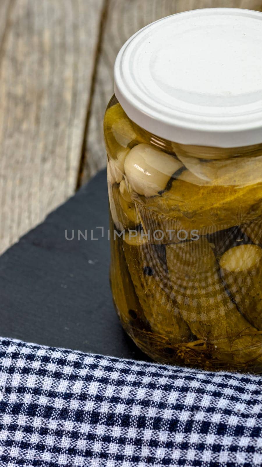 Close up of glass jar with pickles isolated. Preserved food concept, canned vegetables isolated in a rustic composition. by vladispas