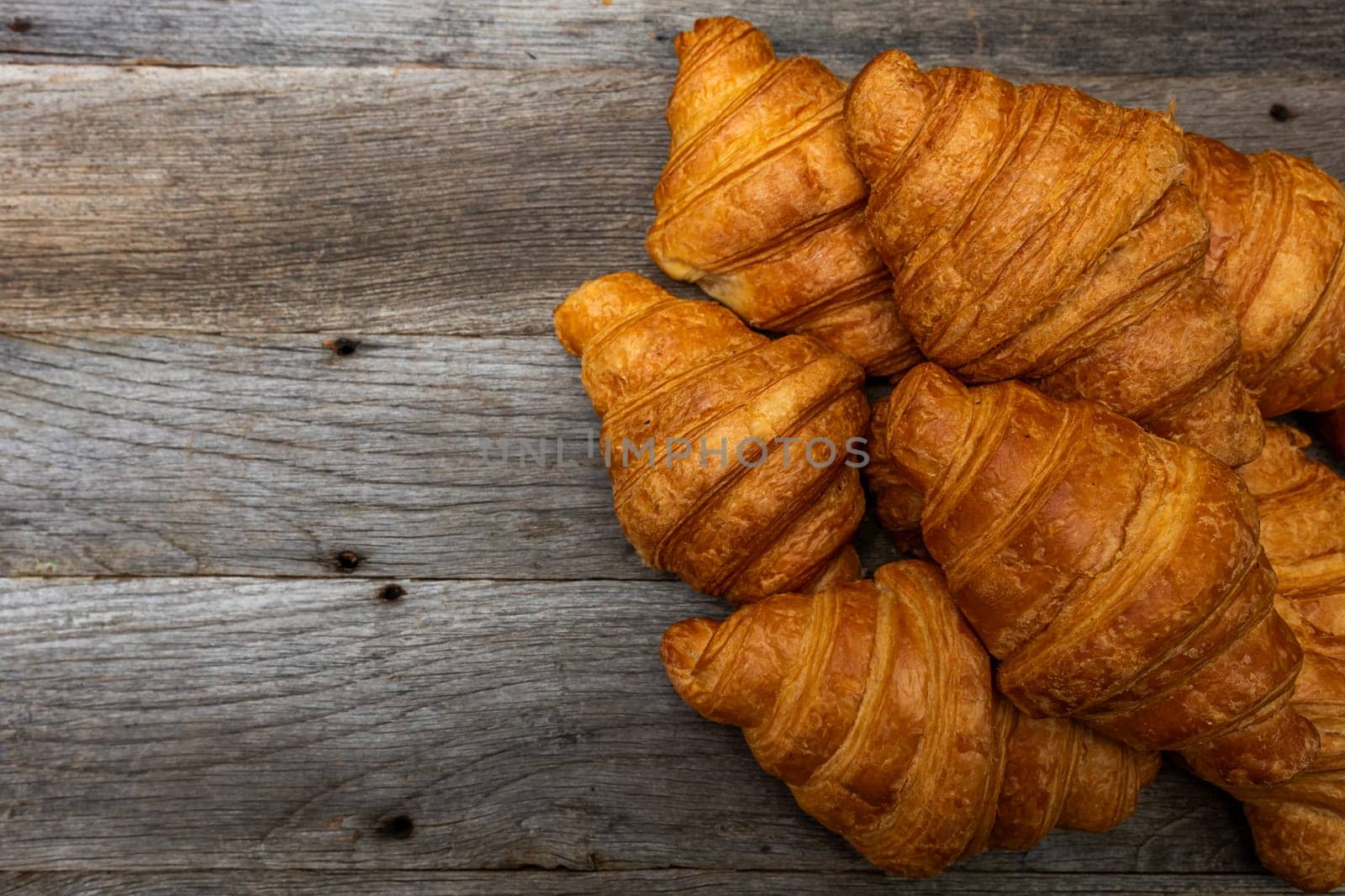 Delicious, fresh croissants isolated on wooden board. French breakfast concept. by vladispas
