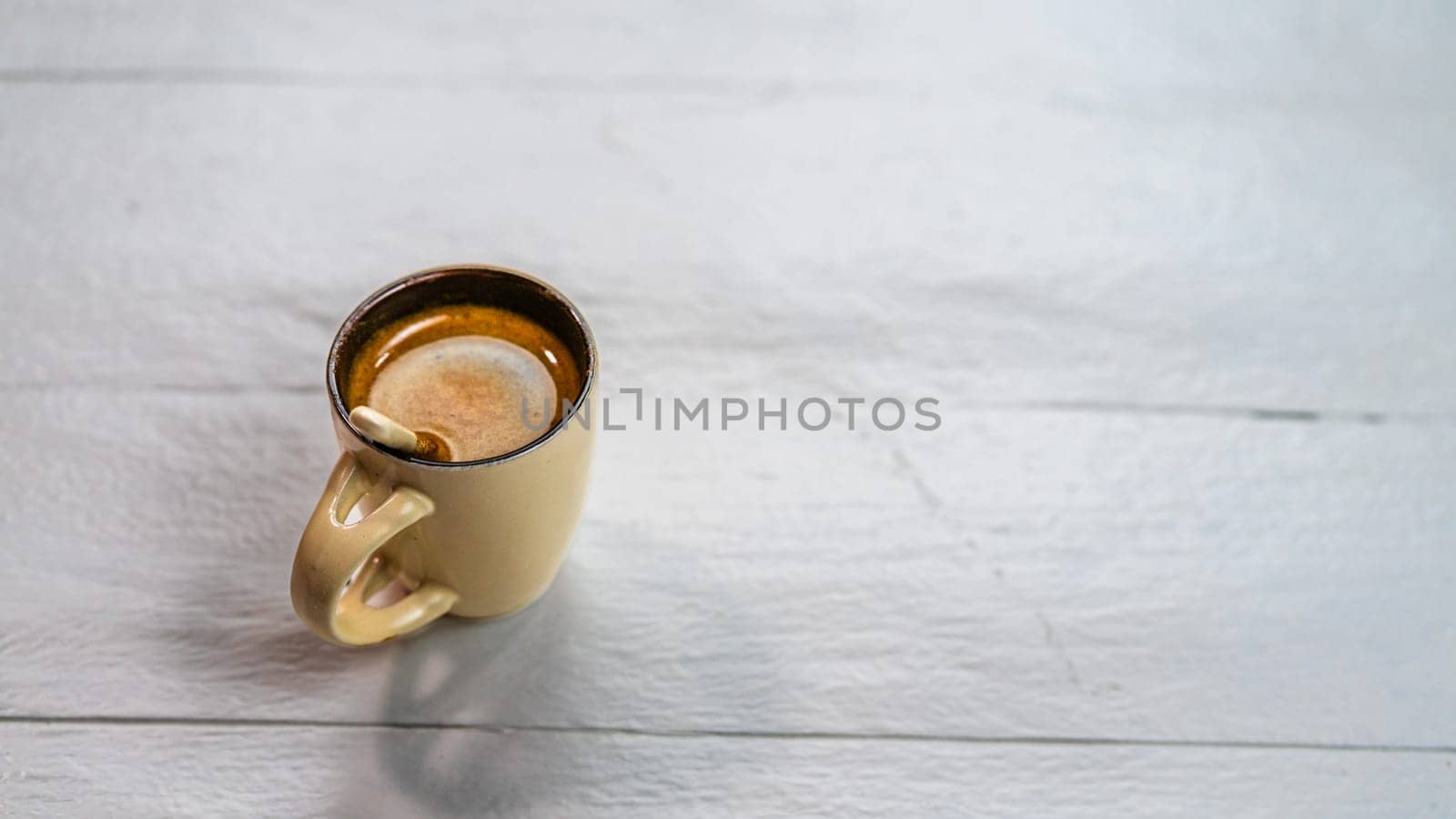 Cup of coffee on a white wooden table. Breakfast concept, top view and copy space by vladispas
