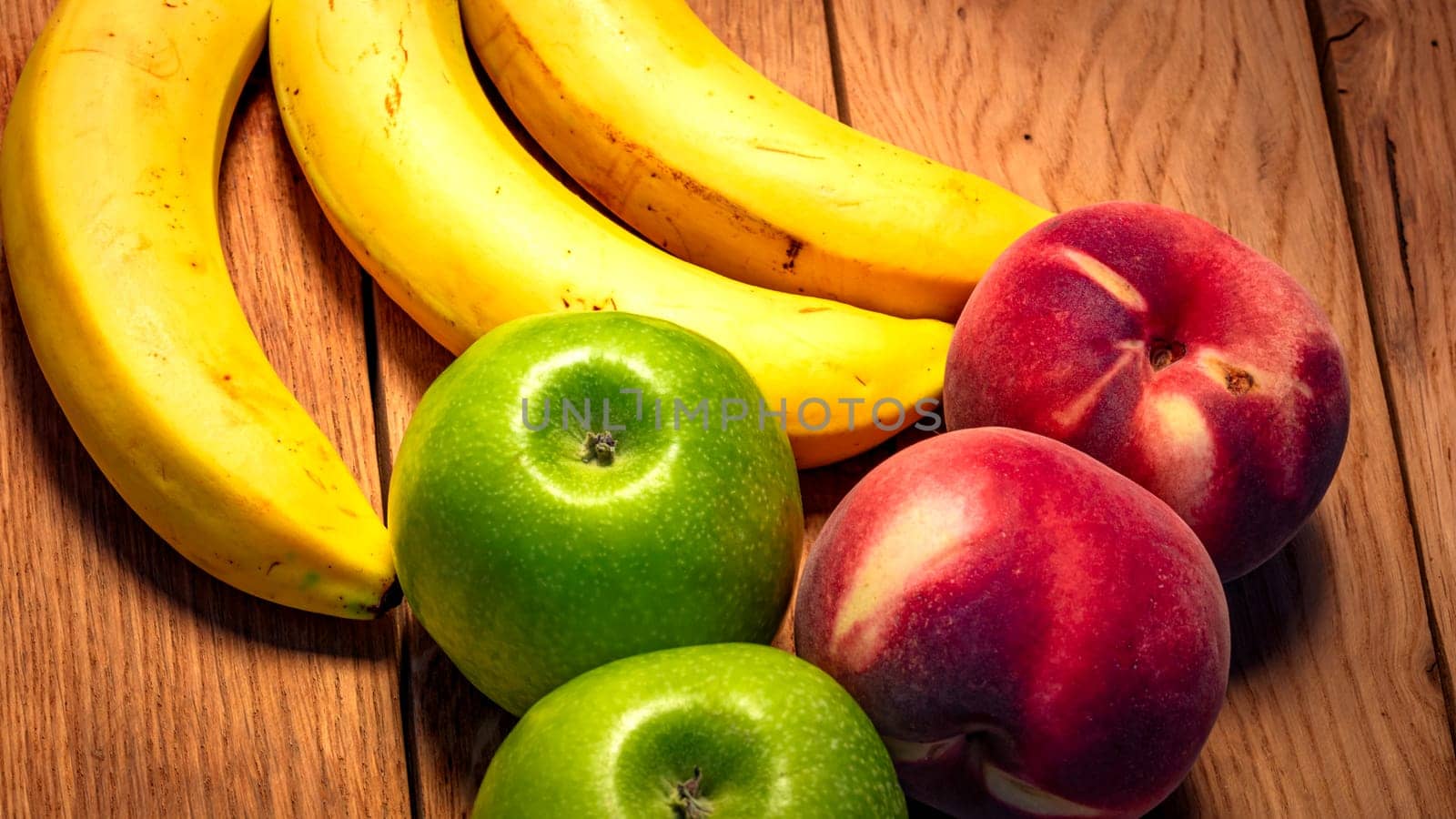 Apple, peach and bananas on a wooden board. Composition of healty fruits. by vladispas