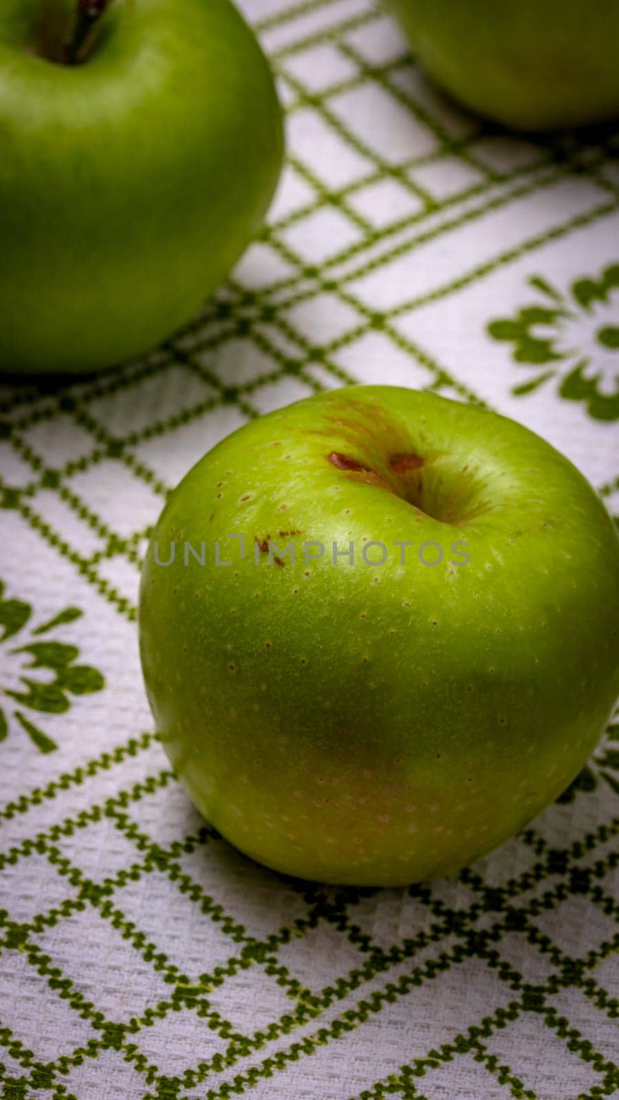  Ripe green apples on a rustic napkin on wooden table. by vladispas