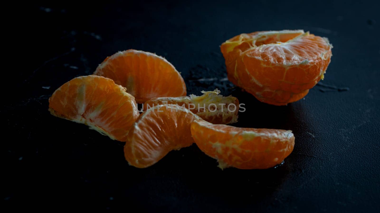 Sliced oranges on black background. Fresh fruit isolated on black by vladispas