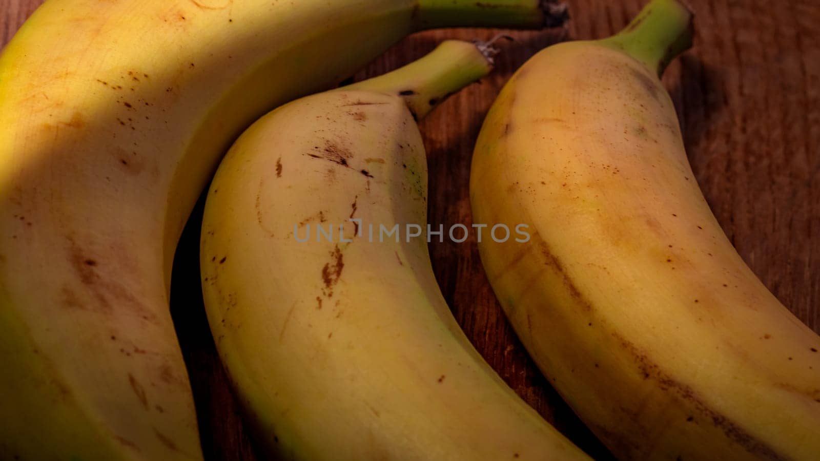 Fresh ripe bananas on a wooden board. by vladispas