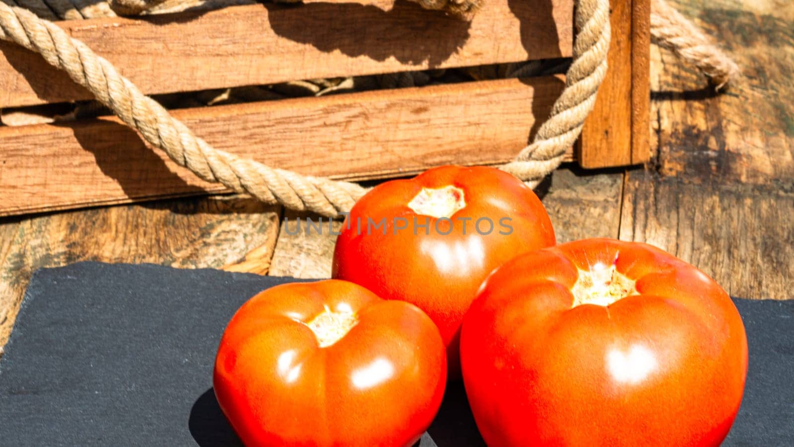 Close up of fresh ripe tomatoes isolated in a rustic composition, by vladispas