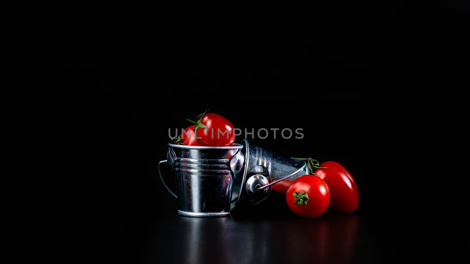 Selective focus on composition with mini decorative bucket and tomatoes. Small metal bucket with cherry tomatoes by vladispas