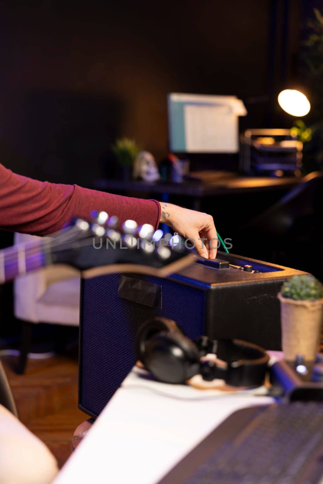 Sound producer adjusting volume levels on home studio amplifier before recording guitar tunes for mixing and mastering session. Male composer creating a new song with stereo gear. Close up.