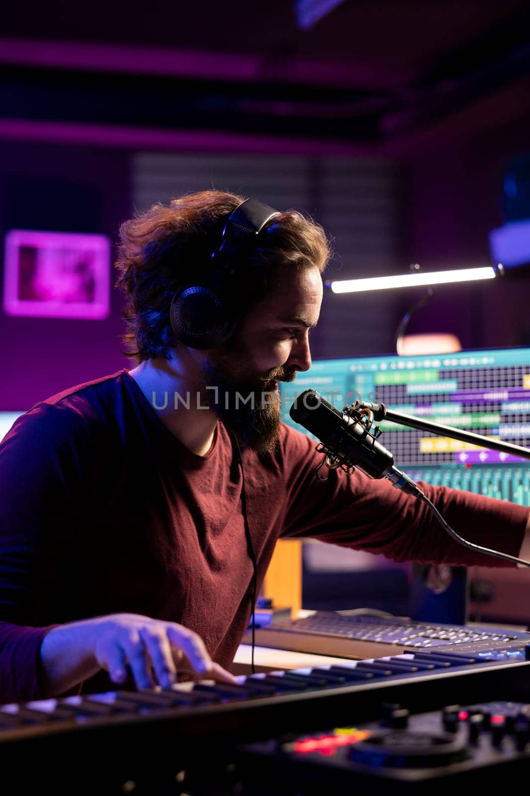Sound engineer recording piano keys notes and singing on microphone, producing new music with electronic gear. Musician composing songs on midi controller, home studio equipment.