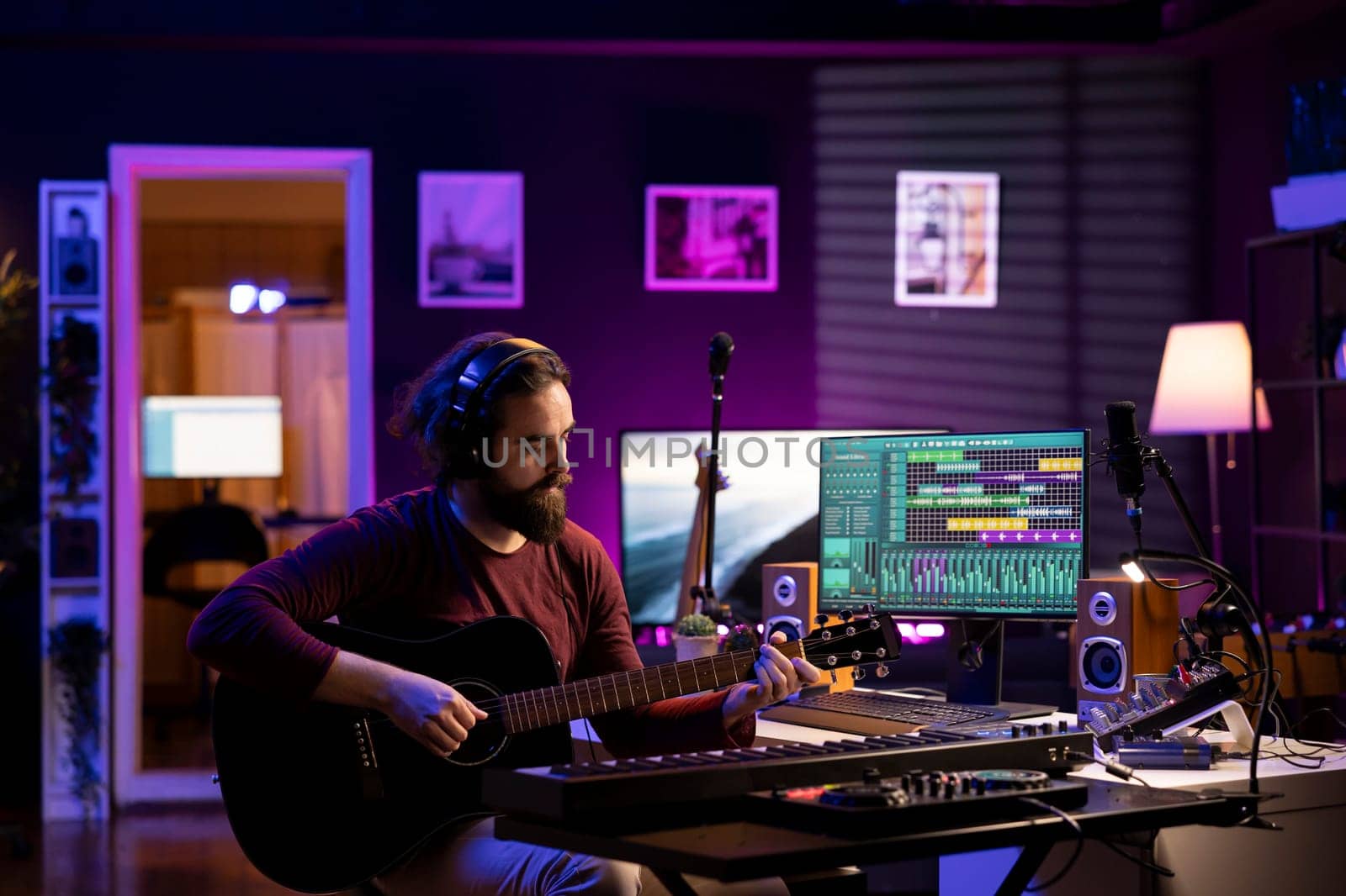 Skilled singer producer recording guitar tunes and adding piano key sounds, creating a beautiful song with mixing console and daw software on pc. Acoustical engineer working with electronic gear.