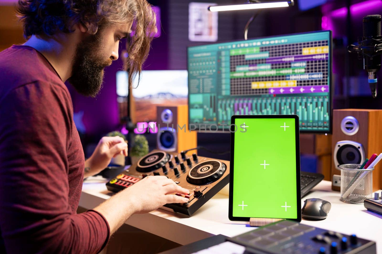 Composer creating soundtracks on stereo gear and greenscreen display by DCStudio