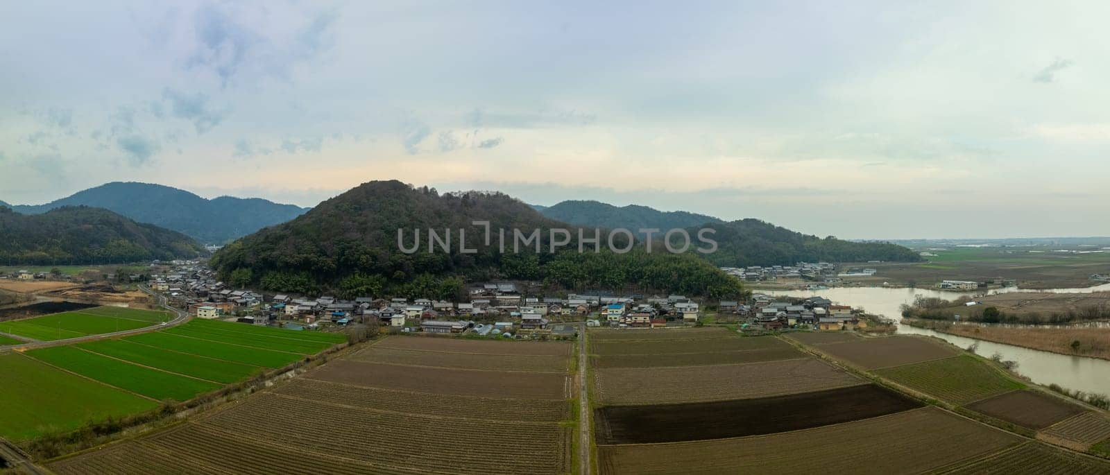 Panoramic aerial view of plowed fields by small village in Shiga, Japan. High quality photo