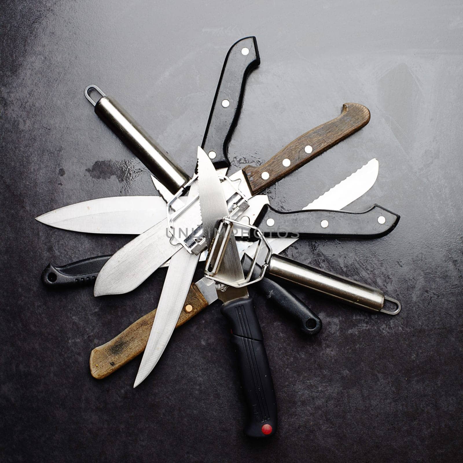 Kitchen, knives and tools with peeler on table in restaurant for cooking with professional set. Steel, service and metal slicer utensils on counter in cafe or culinary equipment for meal prep by YuriArcurs