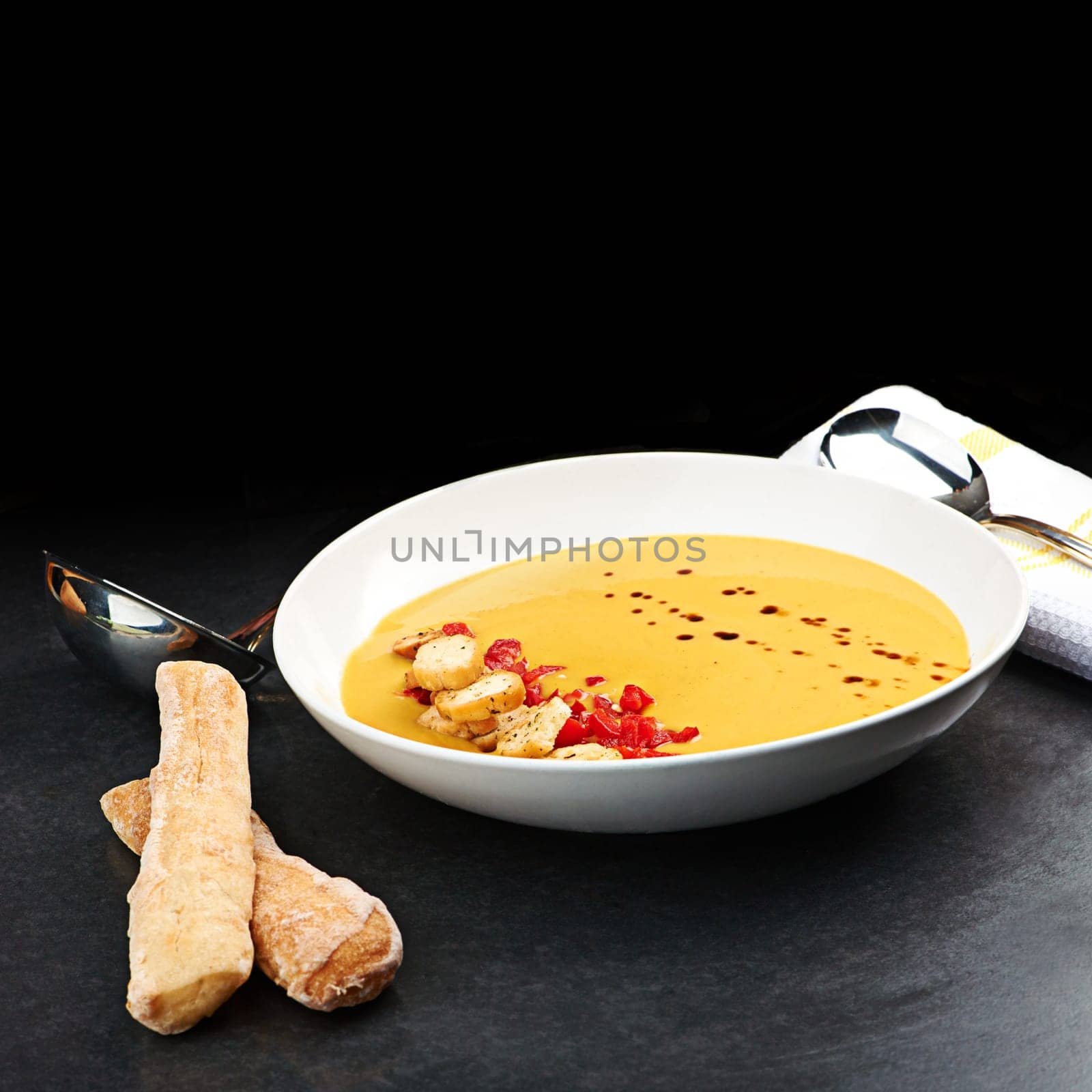 Vegetable, soup and bread on menu in restaurant with chilli, garlic and healthy food in diet. Dinner, dish and luxury appetizer course with breadsticks in fine dining kitchen or benefits of nutrition by YuriArcurs