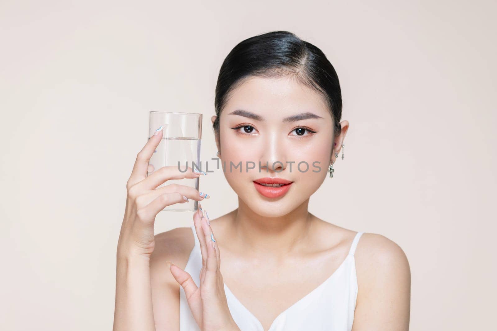 Woman with glass of fresh water in white portrait.