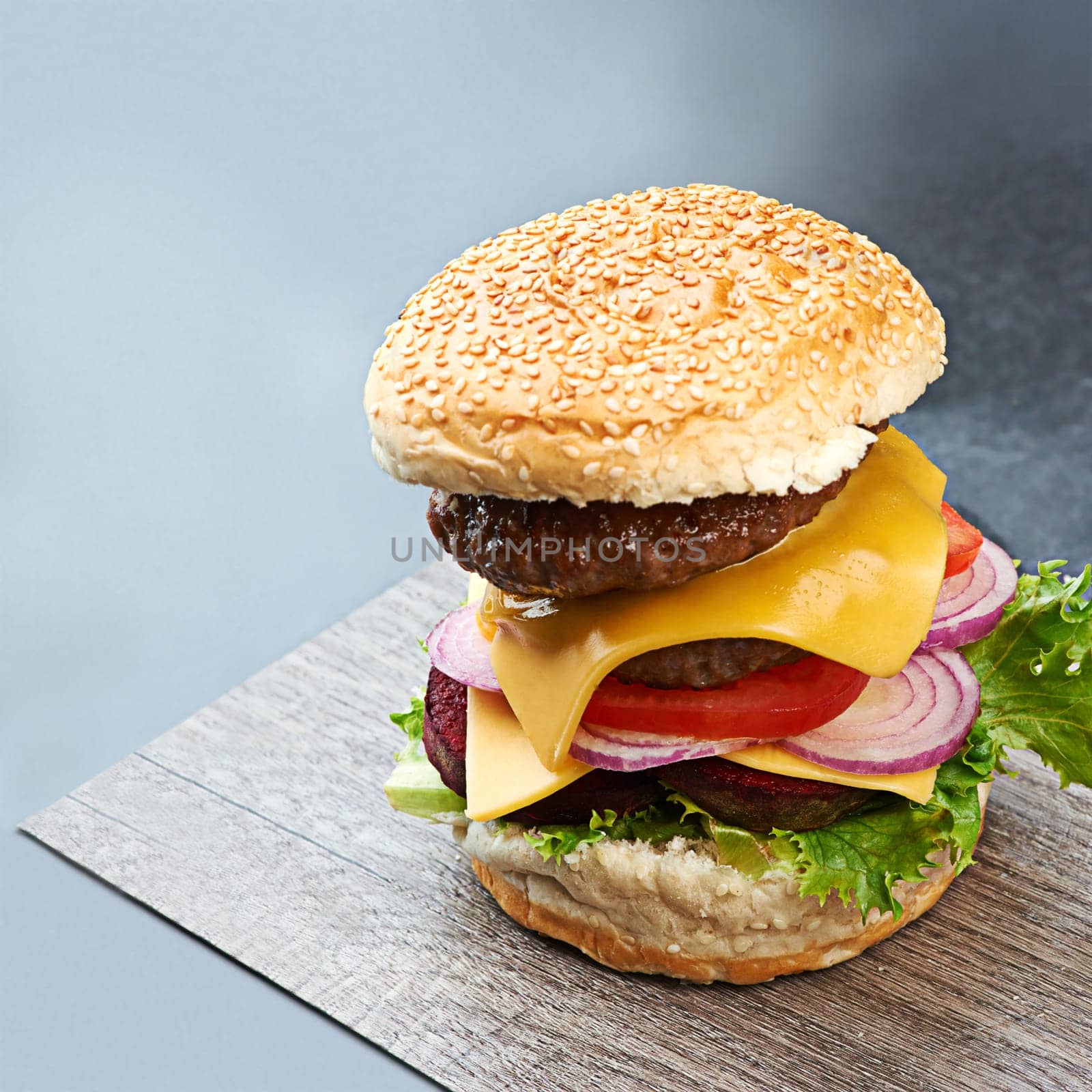 Beef, burger and cheese on menu in restaurant with lettuce, tomato and onion on sesame bun in kitchen. Bbq, hamburger and fast food with meat and salad from fine dining diner for dinner or lunch.