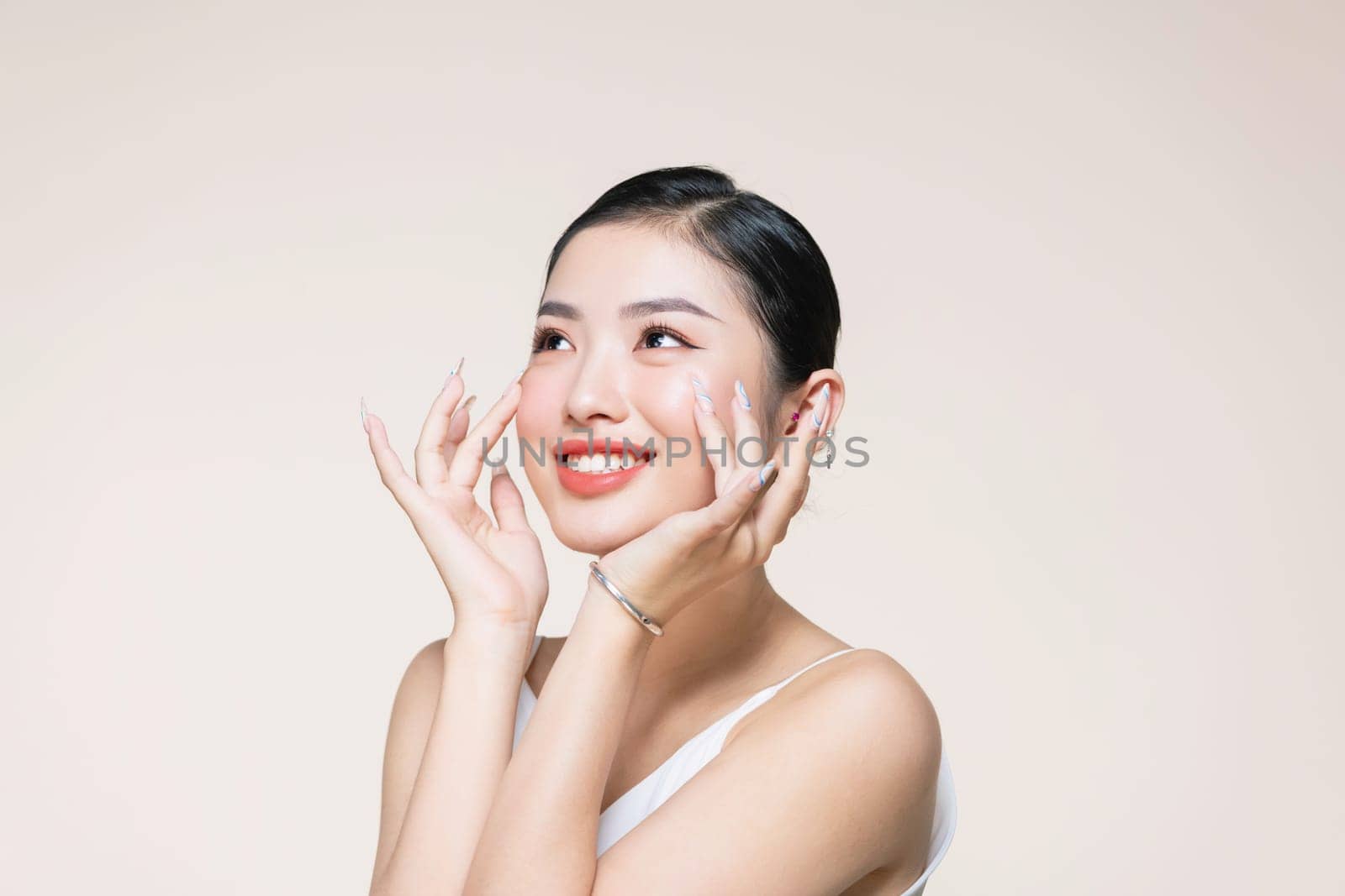 lovely girl with shiny smile touching her cheek, woman with light mua and perfect teeth