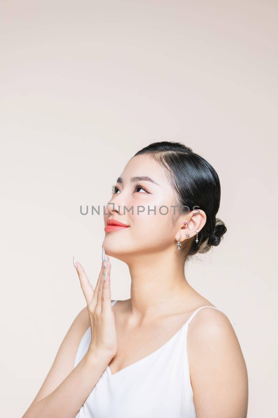 Beauty Model pointing with Finger on Perfect Chin and Neck