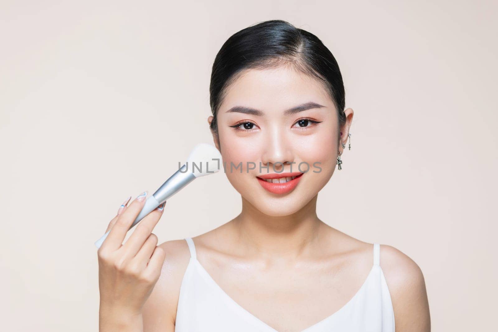 young happy smiling beautiful woman doing contouring apply blush on cheeks