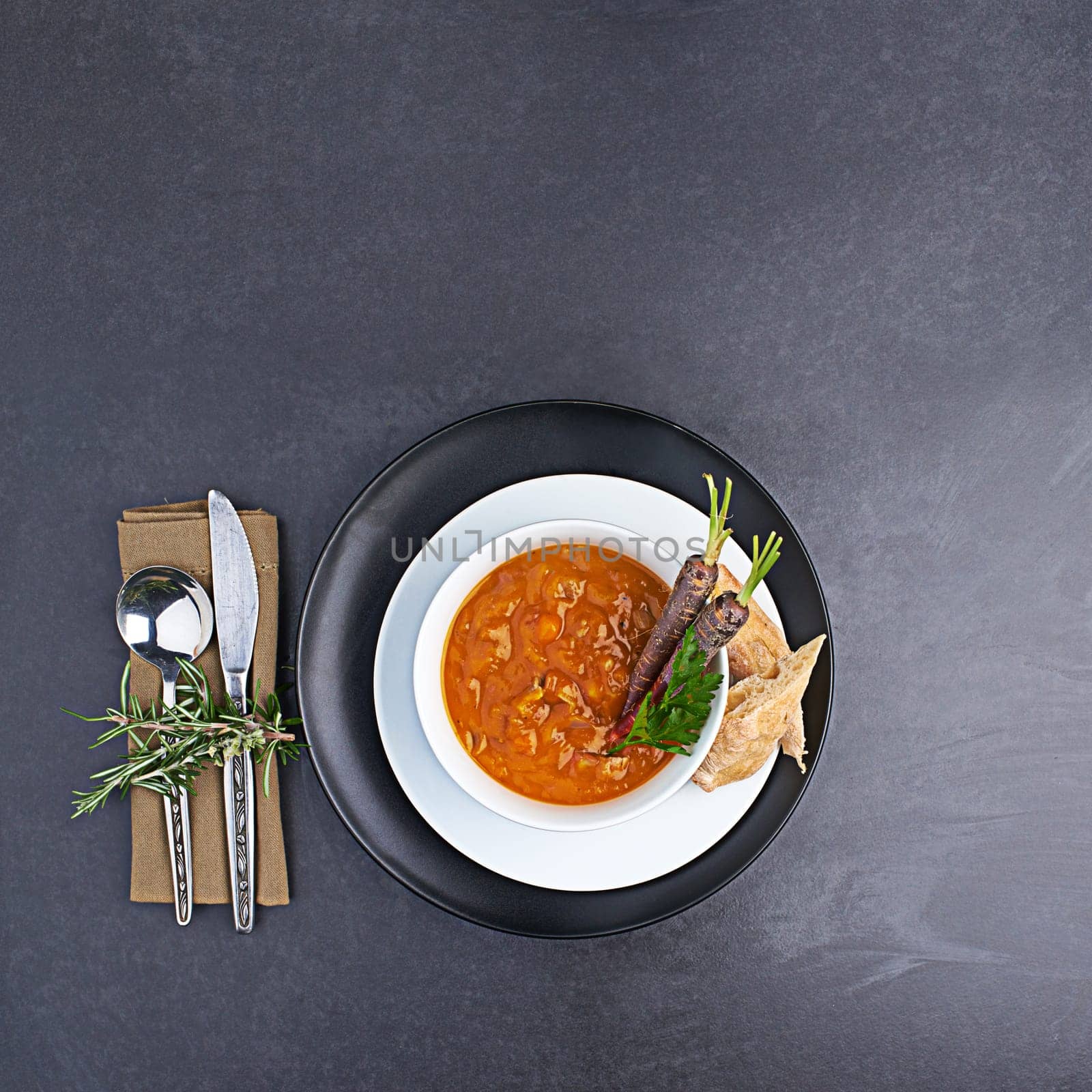 Vegetable, soup and bread on menu in restaurant with bowl of healthy food for diet and nutrition benefits. Dinner, dish and luxury appetizer course in fine dining kitchen with carrot on plate.