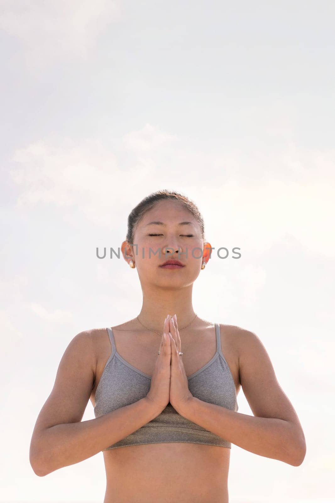 portrait of young asian woman practicing yoga in pray position, concept of mental relaxation and healthy lifestyle, copy space for text