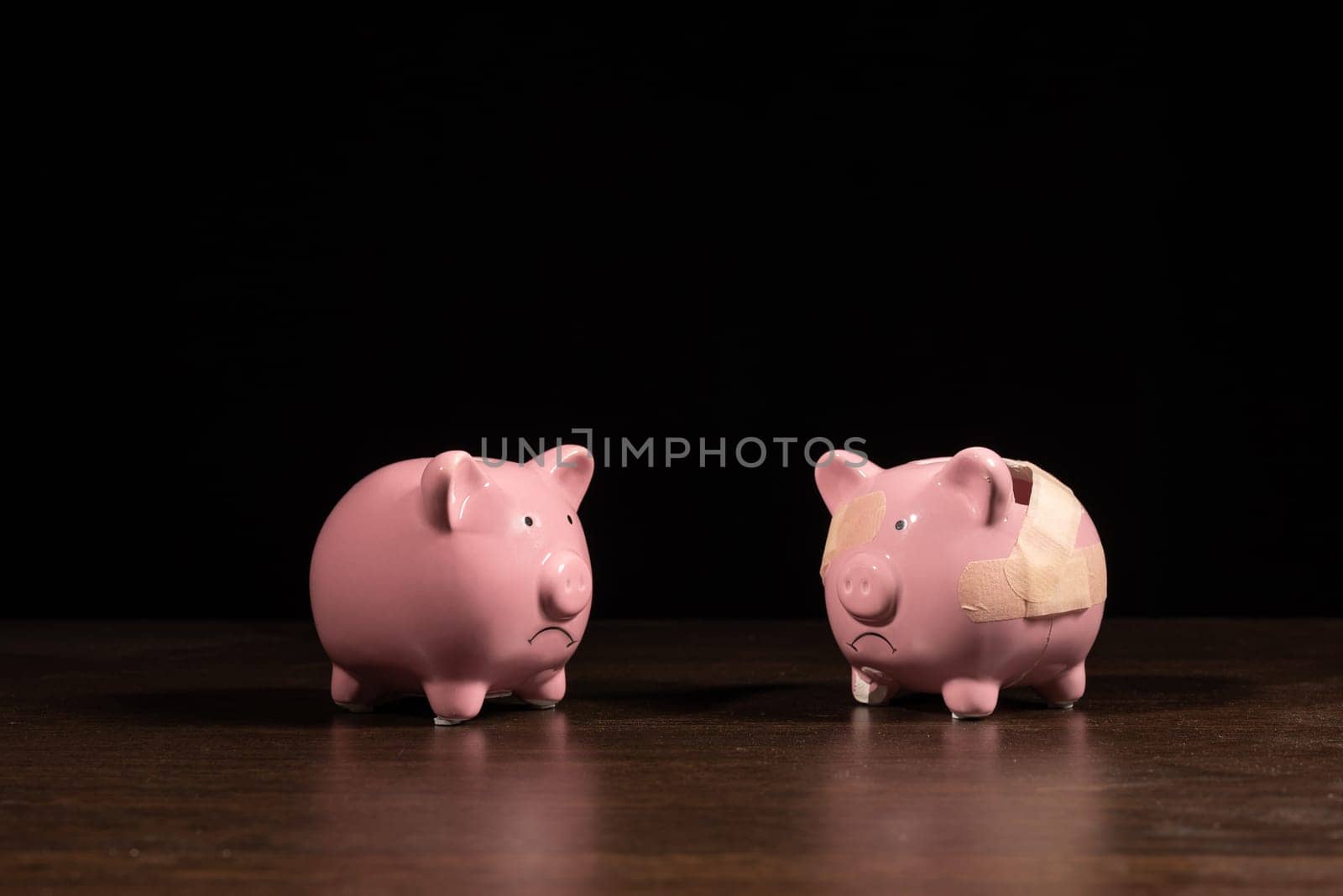 New And Broken piggy bank with band aid bandage or plaster finance background concept for economic recession or bankruptcy