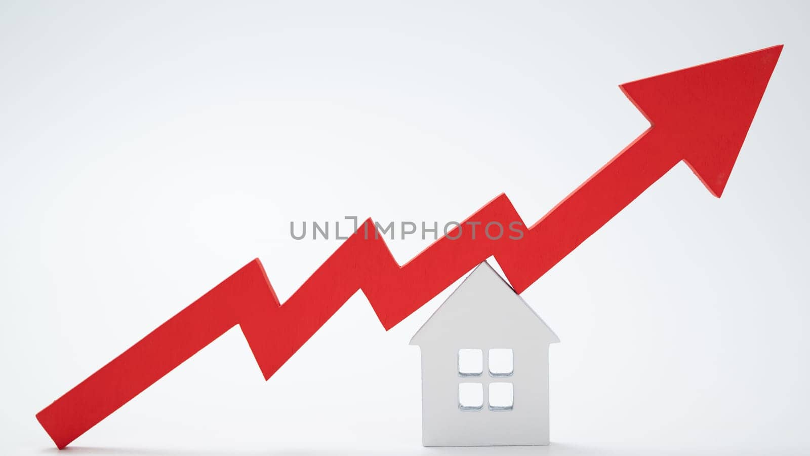 a red up arrow and house. The concept of the rising price of real estate