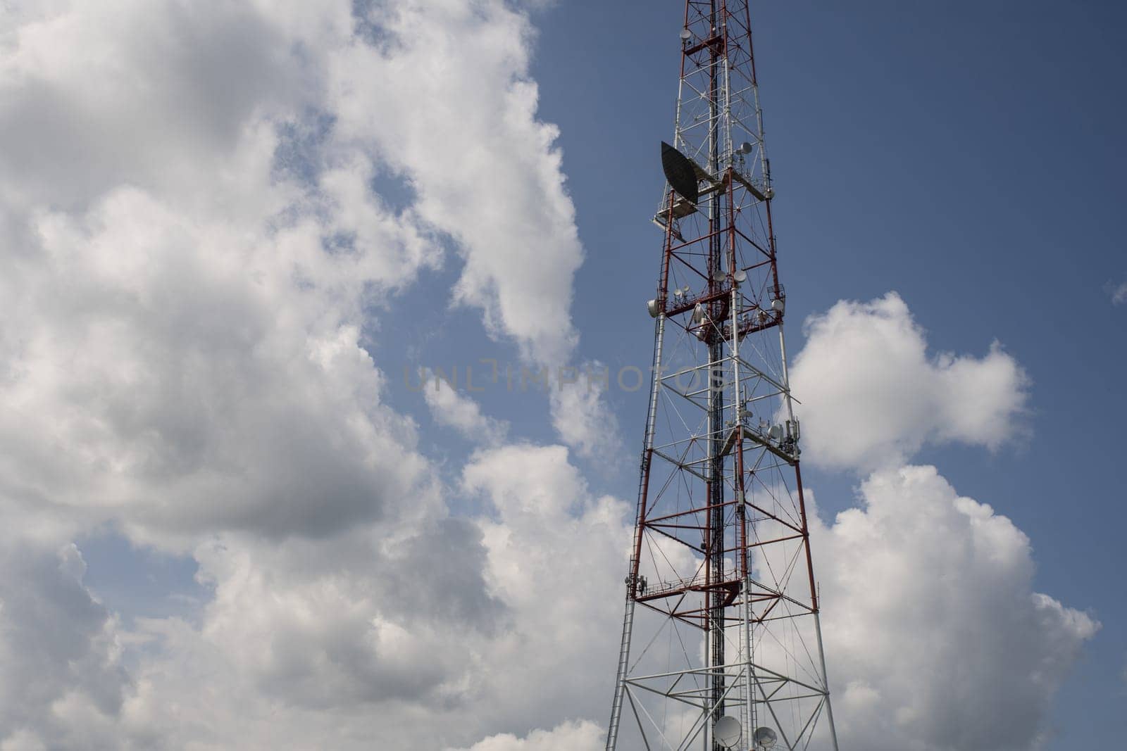 Telecommunication towers include of radio microwave and television antenna system with cloud blue sky by zartarn