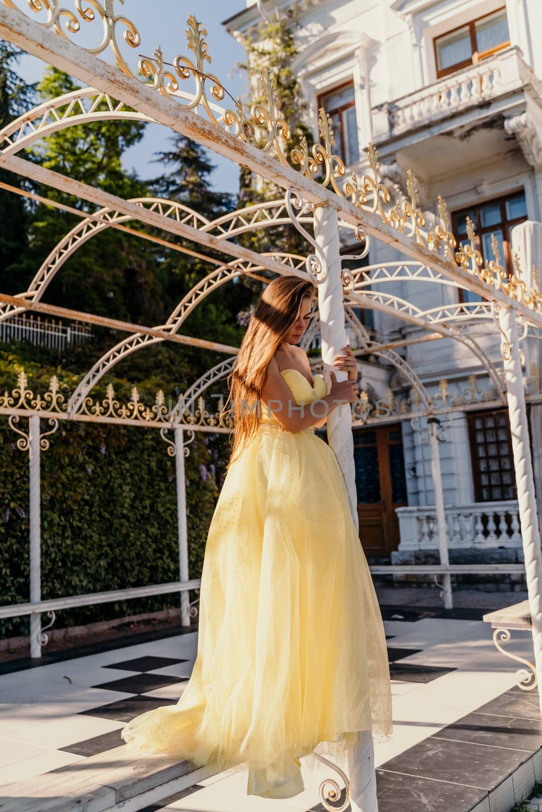 beautiful woman in a long puffy yellow dress posing near the arch by Matiunina