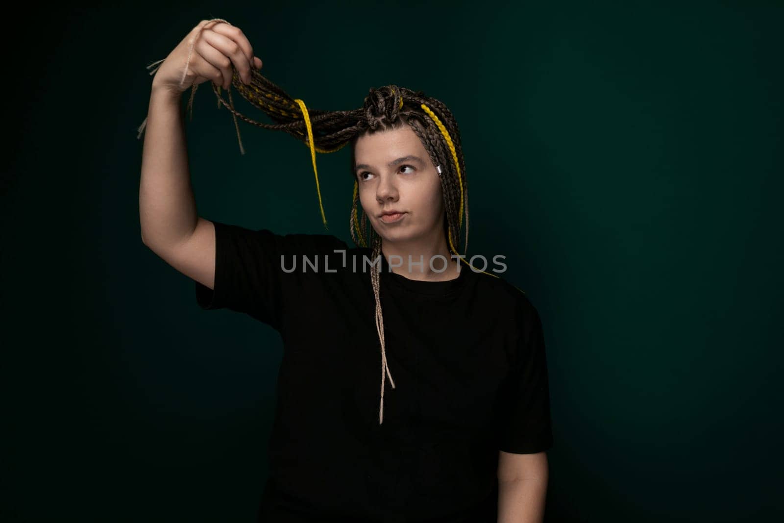 A woman with intricately braided hair is shown holding a pair of scissors in her hand. She appears focused on the task at hand, perhaps preparing to cut her own hair or work on a new hairstyle.
