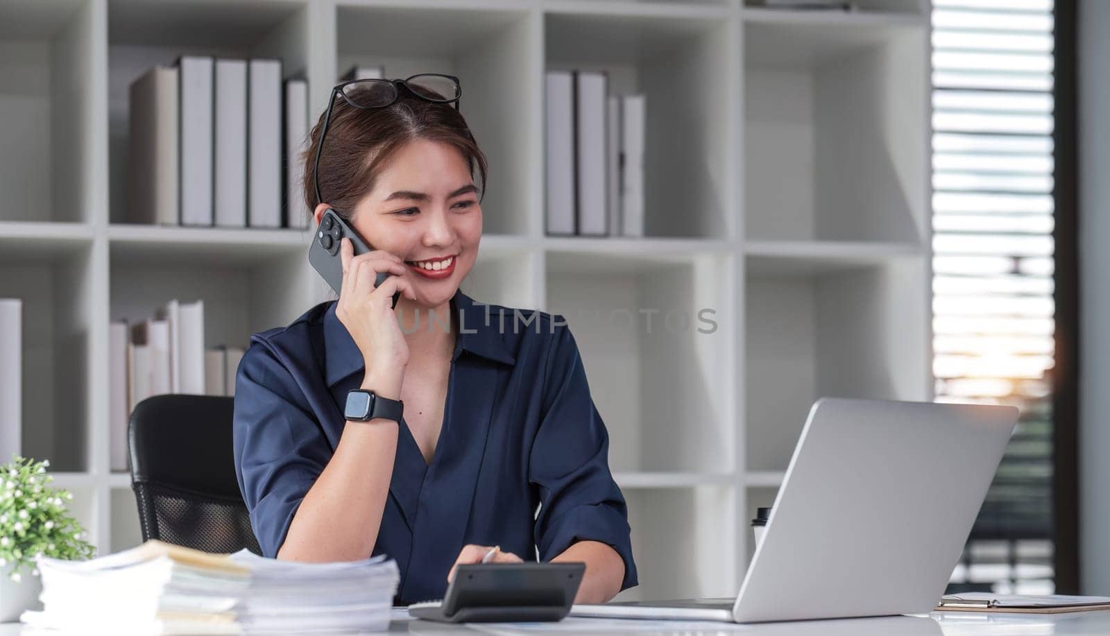 Young accountants use phones and calculators to calculate taxes and manage business accounts in the office..