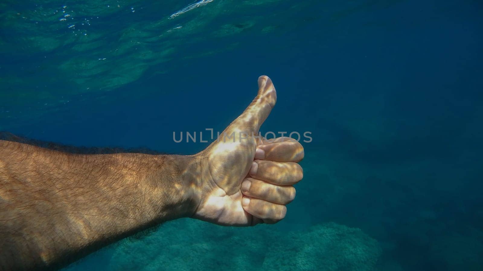 thumb up ok human hand underwater detail by AndreaIzzotti