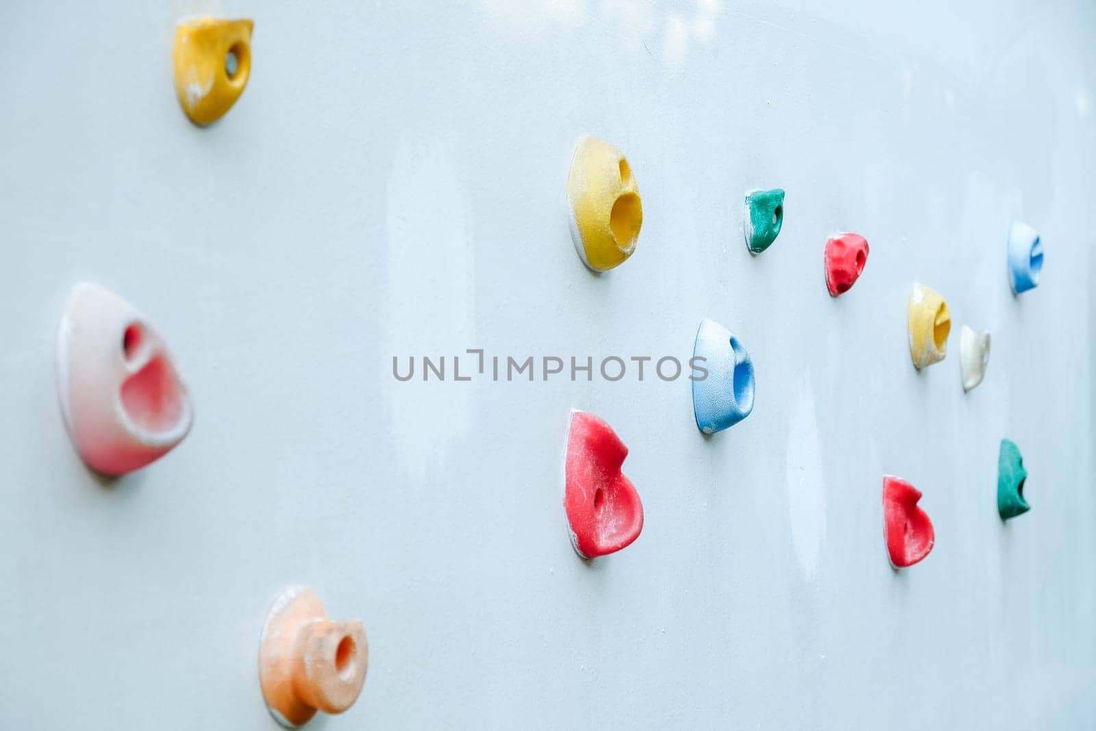 Colorful climbing holds on wall for outdoor rock climbing