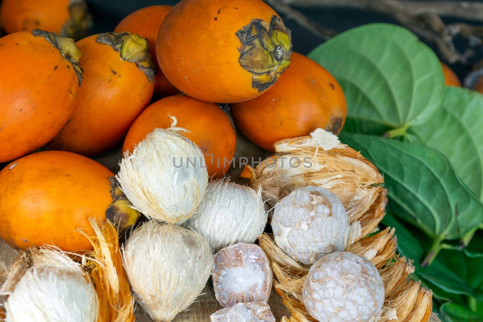 Ripe Betel nut or areca nut with betel leaf isolated on wooden background.