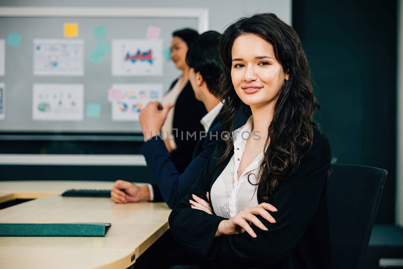 A portrait of a confident businesswoman in a vibrant meeting room. The CEO, manager, and diverse colleagues embody the essence of teamwork, strategy, and success. Workplace collaboration is thriving.