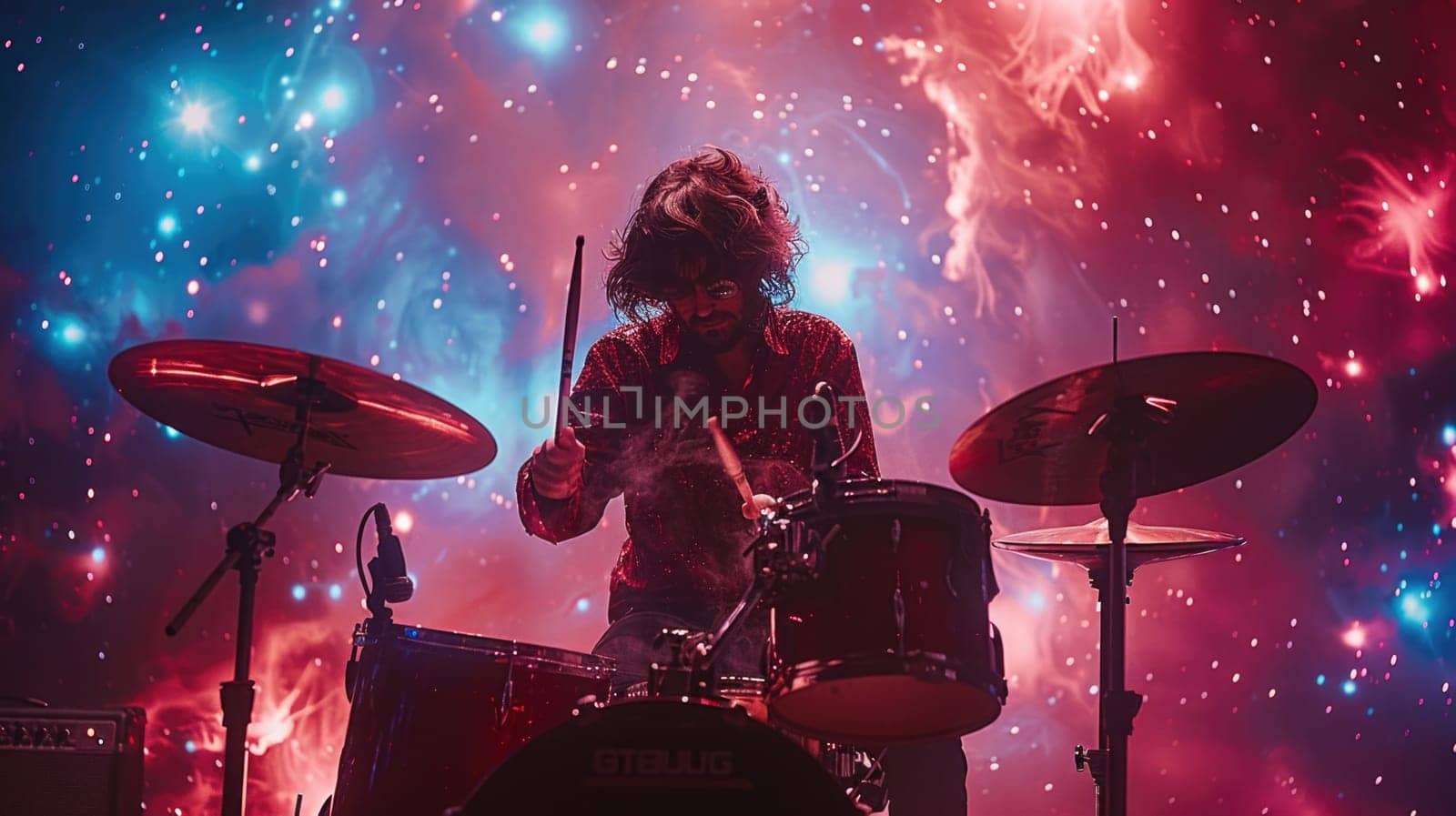 A man playing drums in front of a vibrant, colorful backdrop.