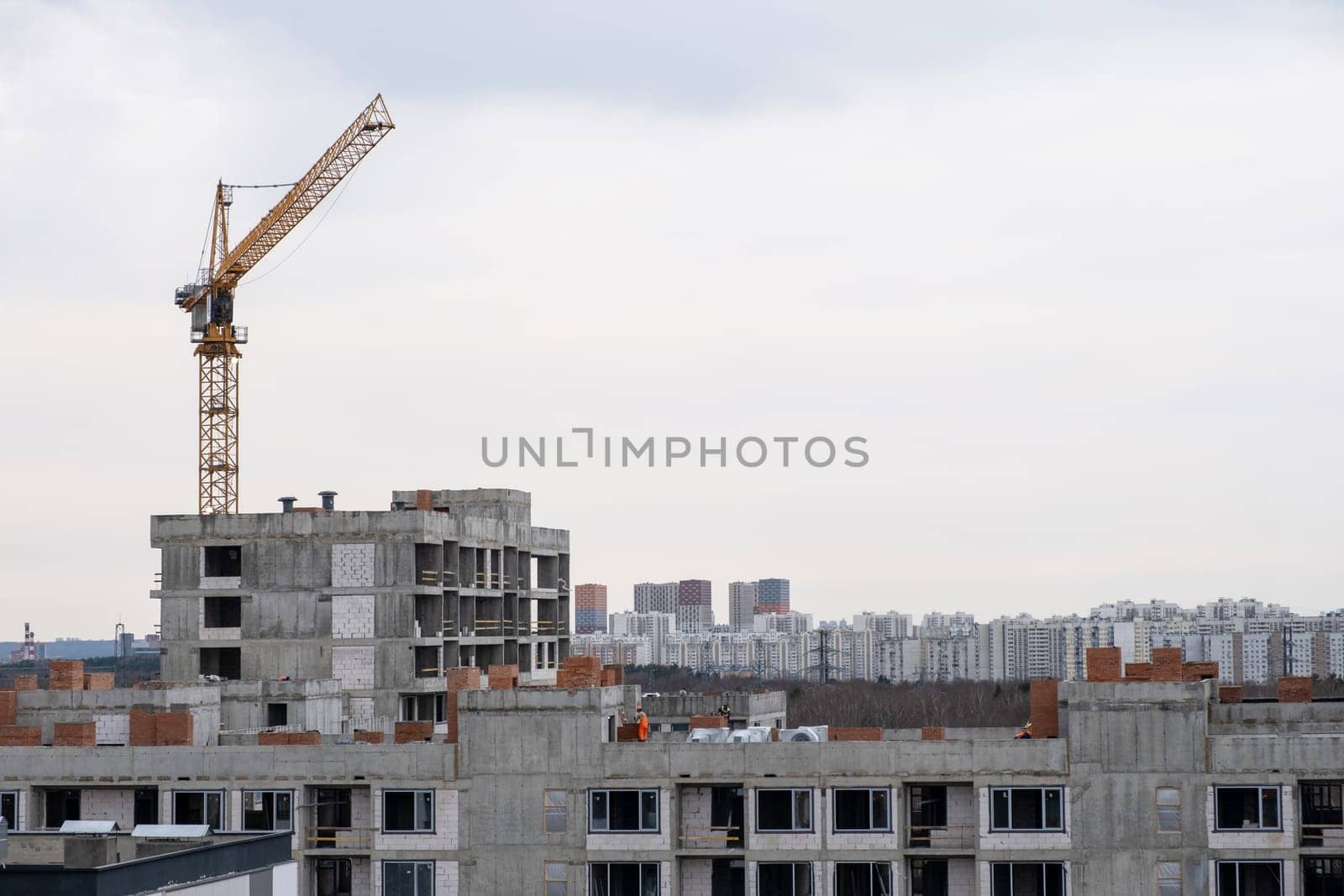 crane and a building under construction against a blue sky background by AnatoliiFoto