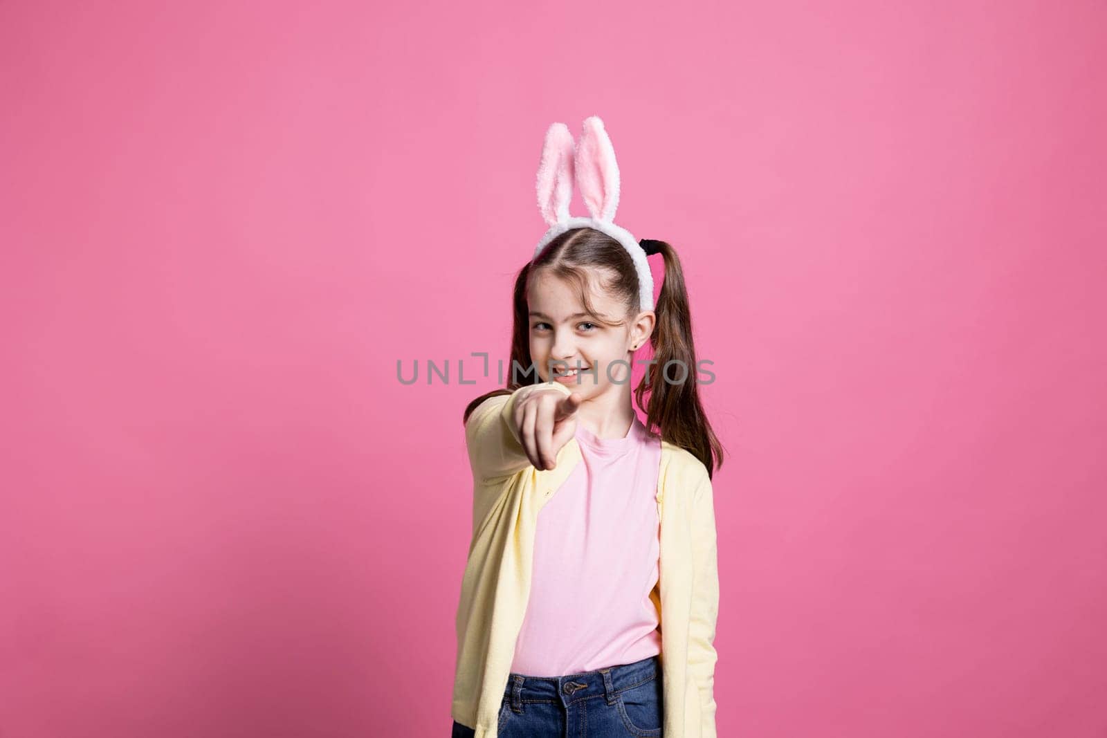 Young schoolgirl with pigtails dancing around in pink studio by DCStudio