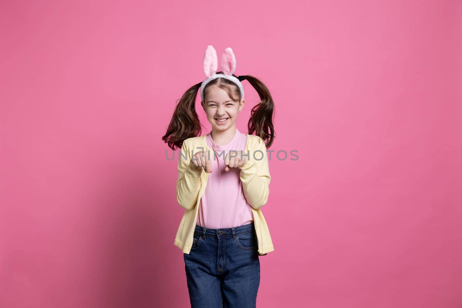 Adorable little girl spending Easter holiday by hopping around like a rabbit by DCStudio