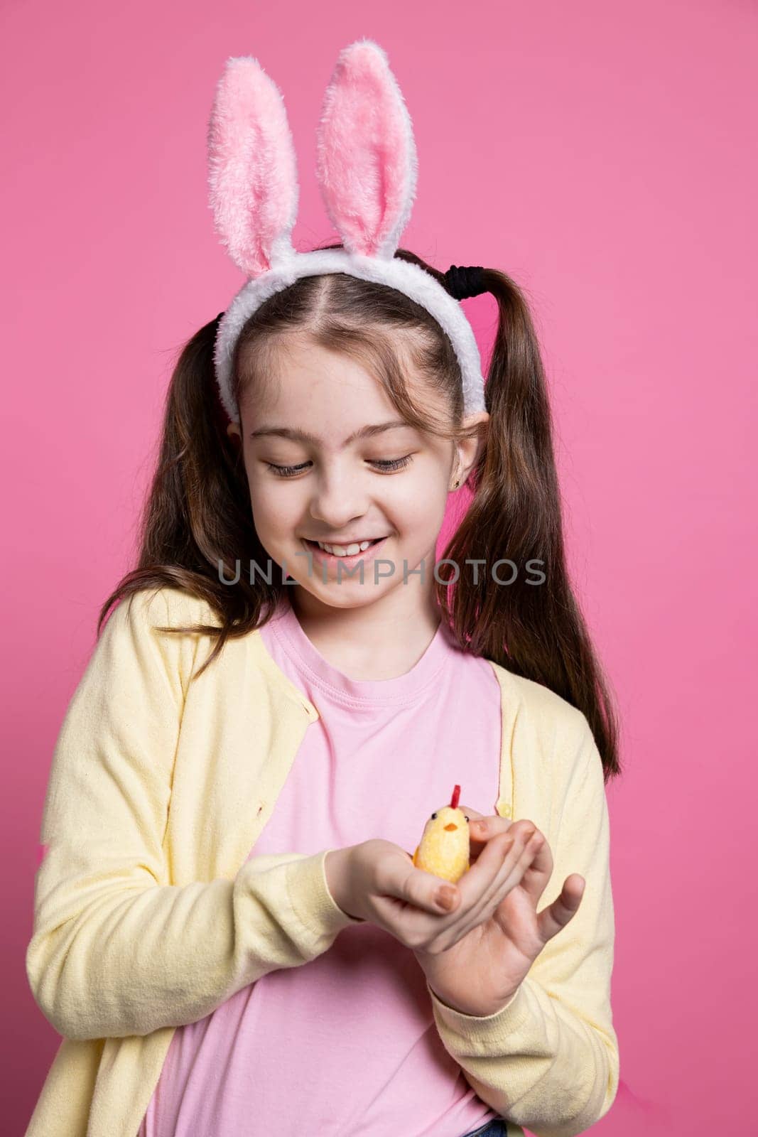 Small young kid showing a cute stuffed chick toy in studio by DCStudio