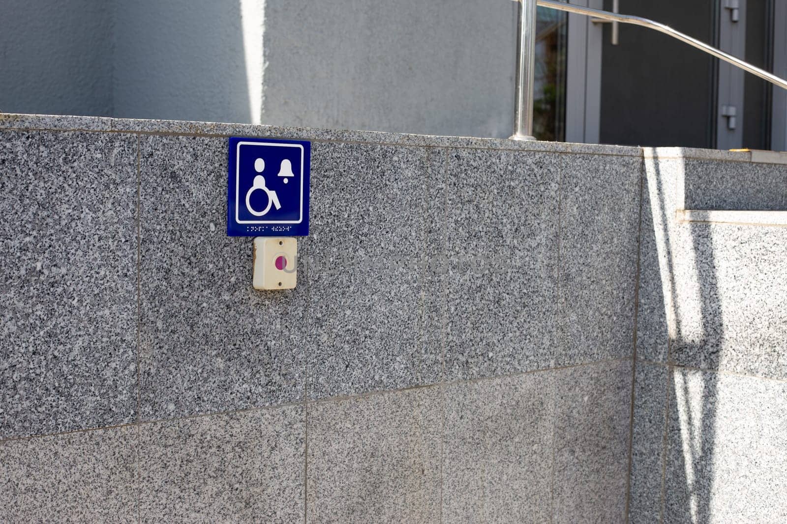 Sign with symbol of person in wheelchair near button to call help by timurmalazoniia