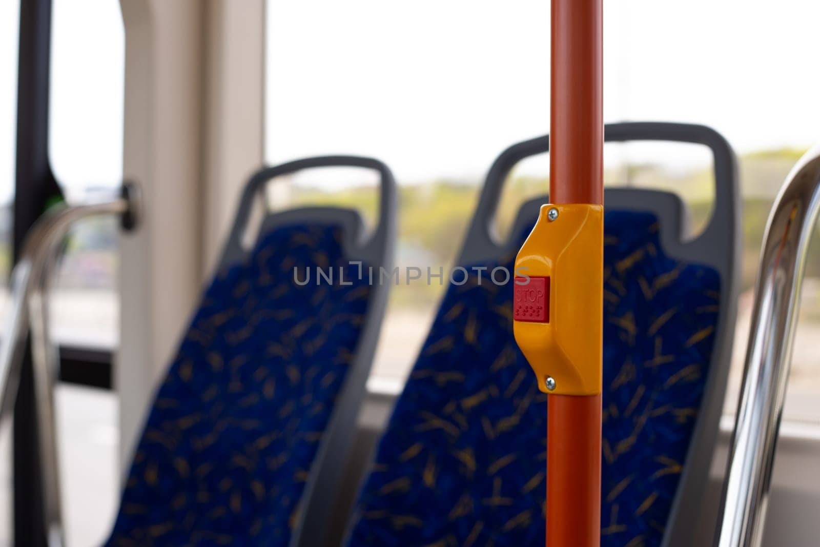 Handrail in city transport with button to stop, stop button in modern public transport with braille text for disabled people
