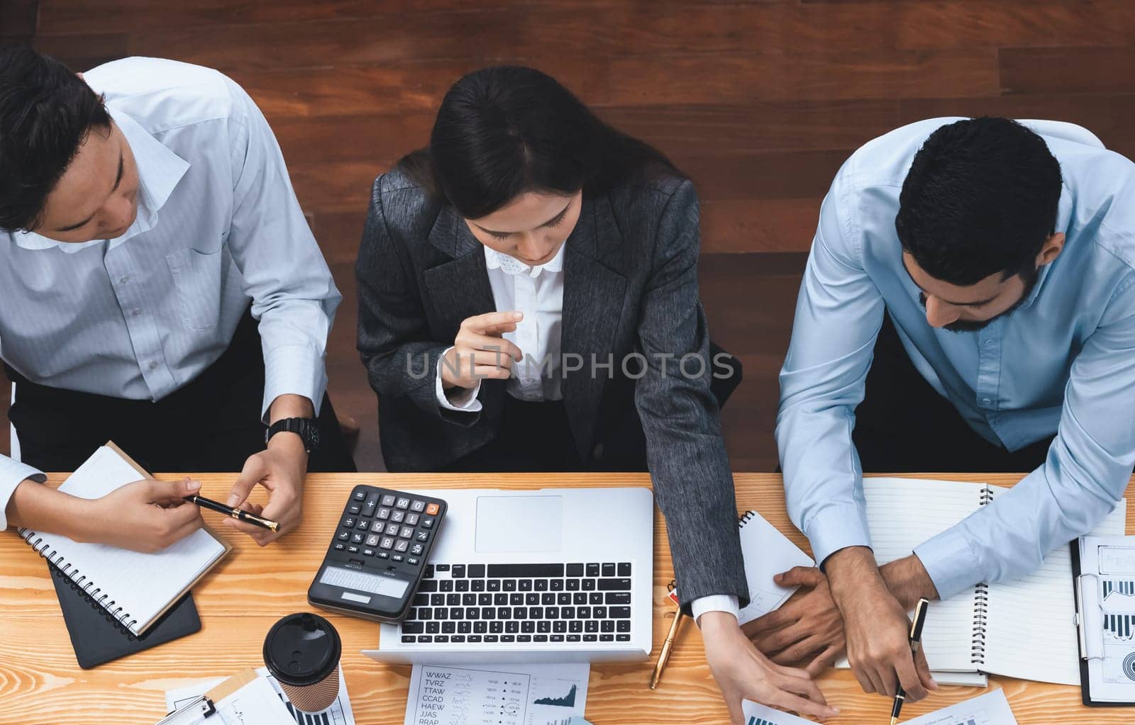 Top view multiracial analyst team use BI dashboard data to analyze financial report on meeting table. Group of diverse business people utilize data analysis by FIntech for business decision. Concord