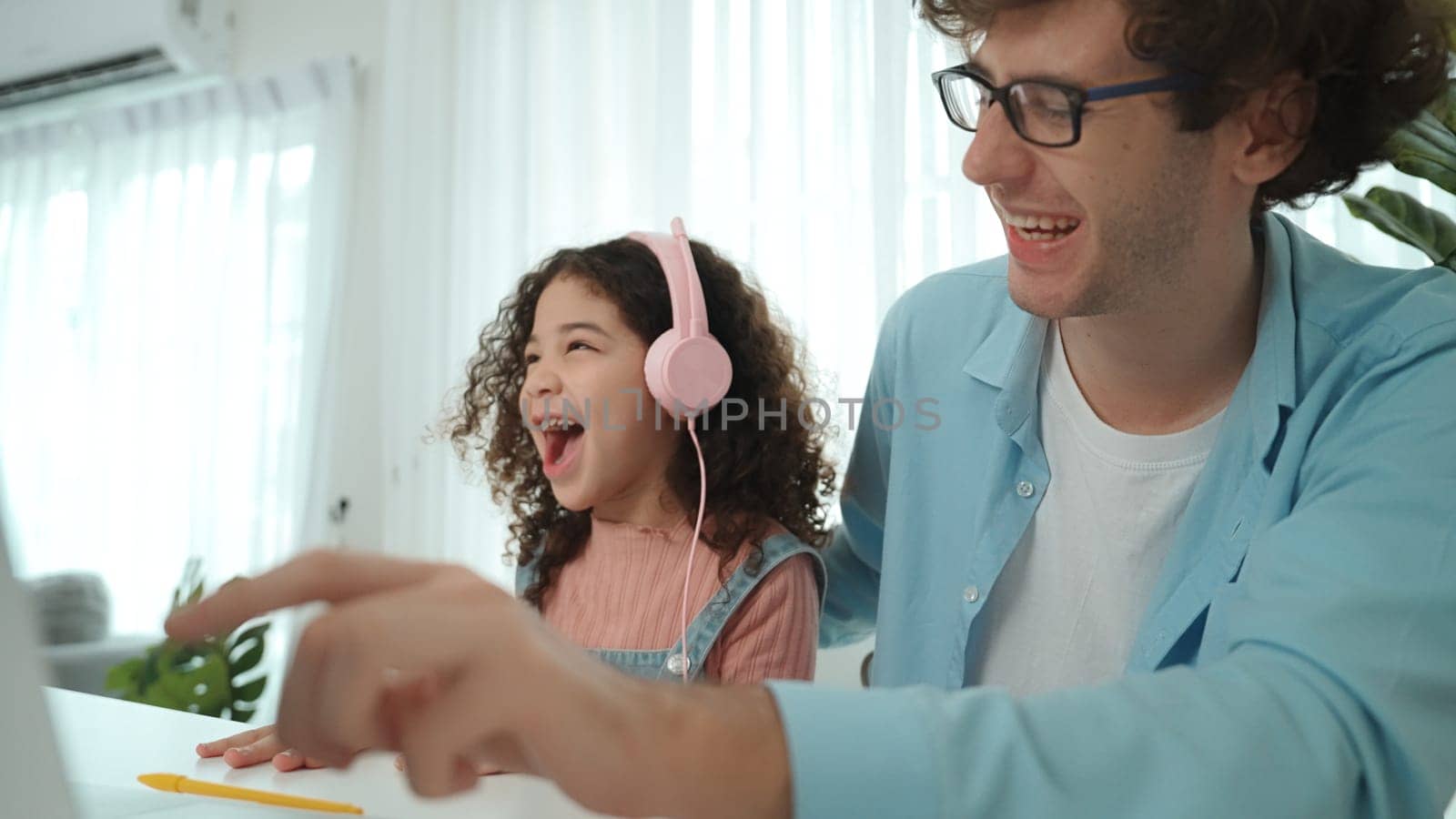 Caucasian dad put headphones on daughter while girl learning code. Father take care schoolgirl while teaching writing engineering prompt and generate Ai by using laptop. Online learning. Pedagogy.