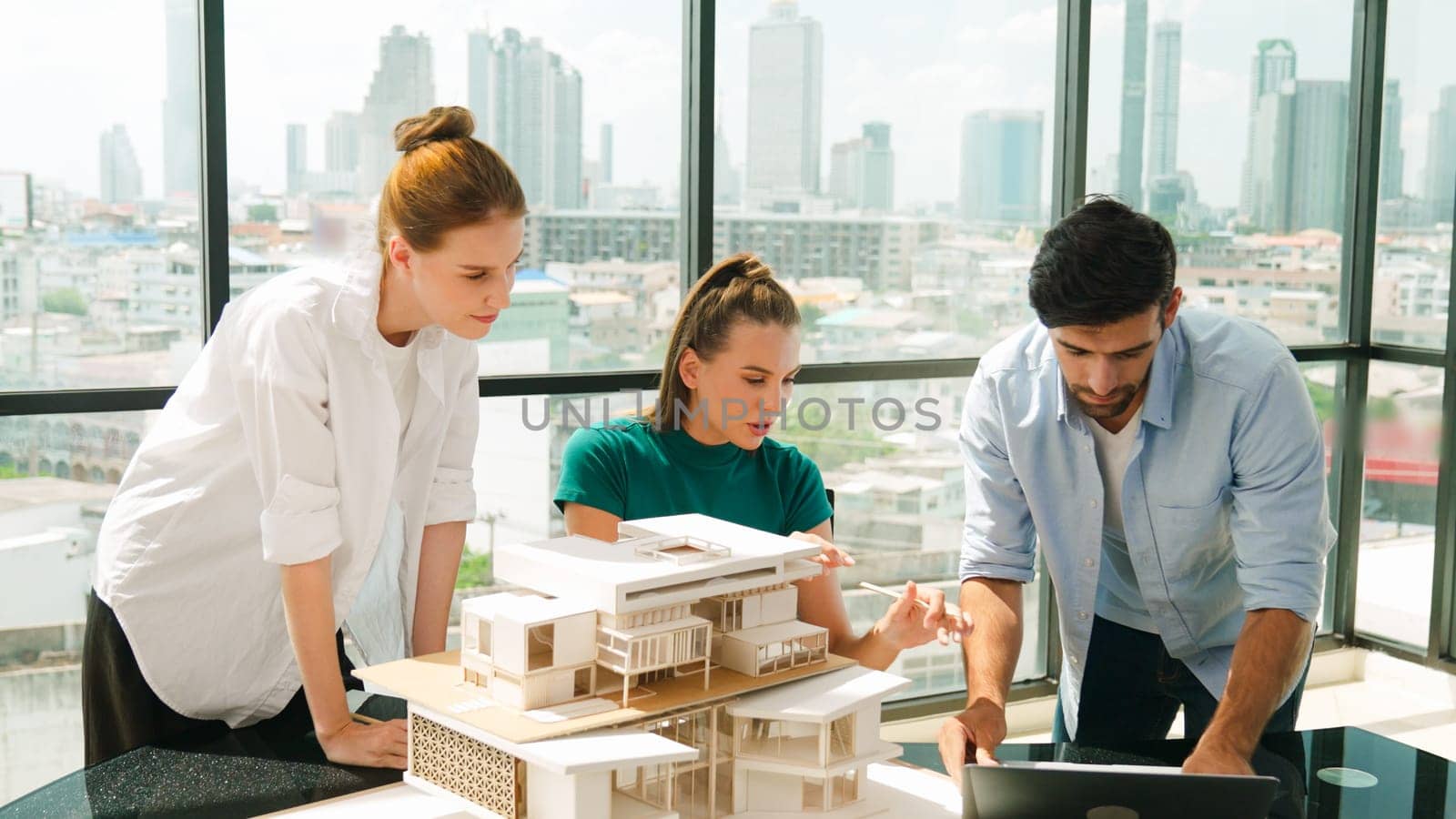 Smart architect team discussion about house design while handsome male worker present idea by using laptop. Group of professional engineer sharing, brainstorming design. Business design. Tracery