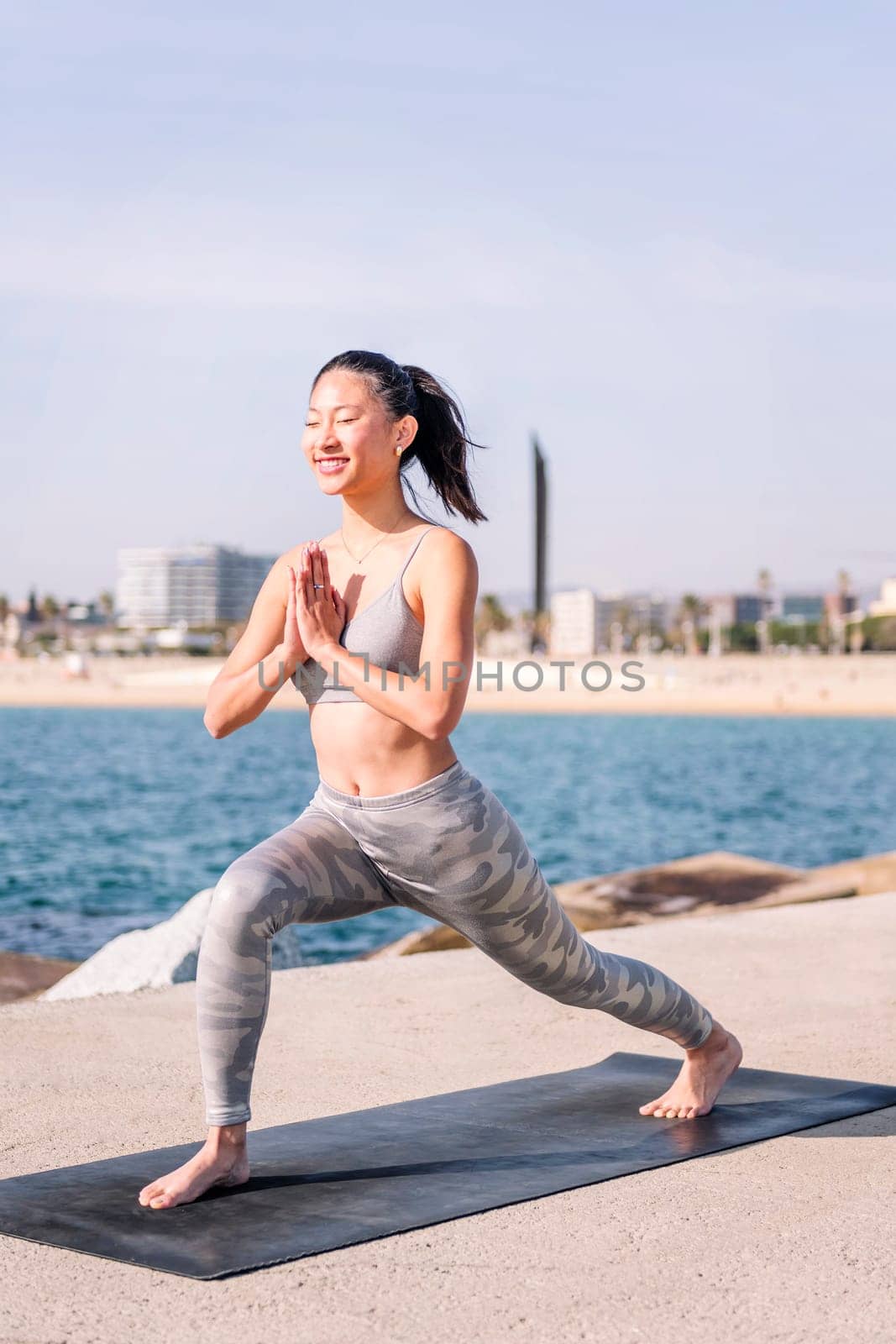 young asian woman in sportswear practicing yoga by the sea, relaxation and healthy lifestyle concept
