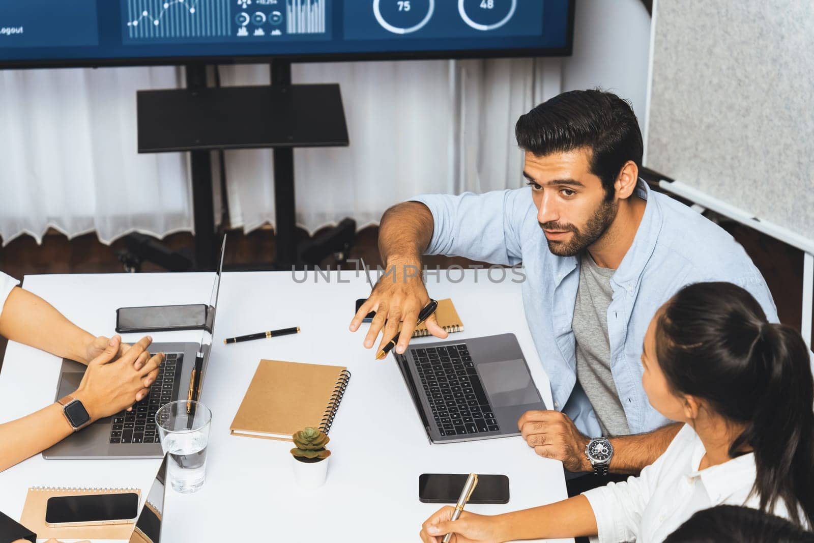 Analyst team utilizing BI Fintech to analyze financial data at table in meeting room. Businesspeople analyzing BI dashboard power on paper for business insight and strategic marketing planning.Prudent