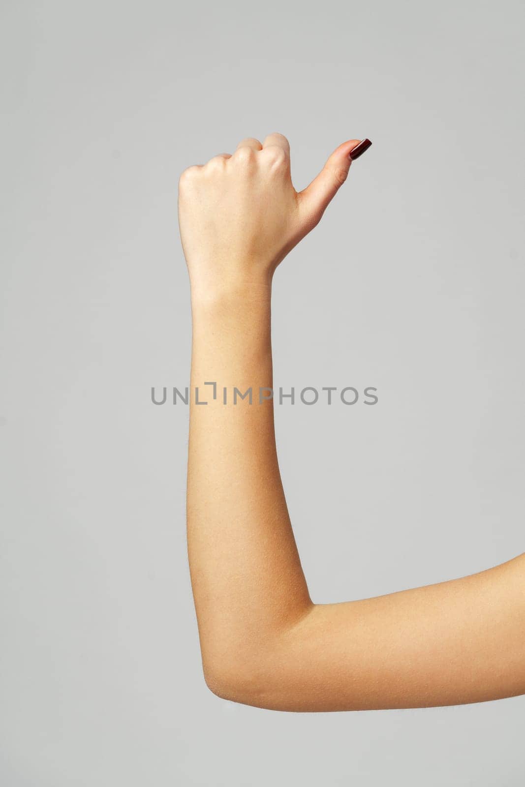 Female hand OK sign on gray background close up