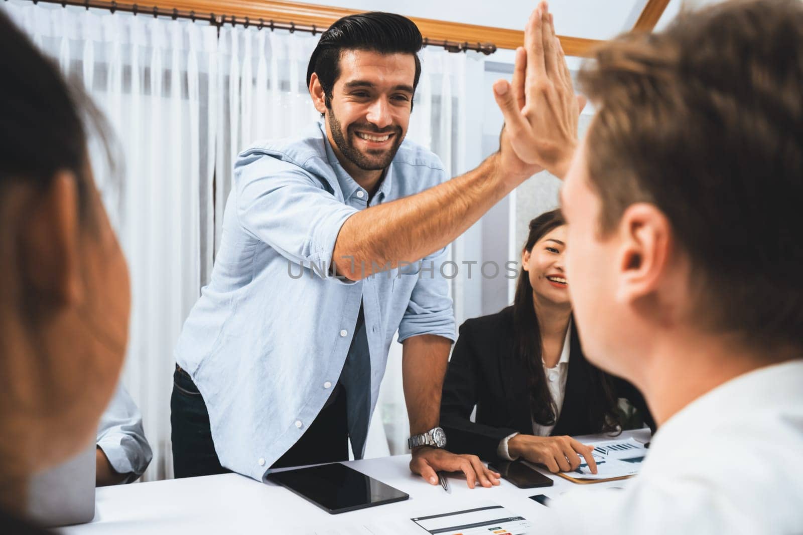 Analyst team leader celebrate and high five together with his colleague after successful data analysis meeting using FIntech software power with business intelligence or BI dashboard. Prudent