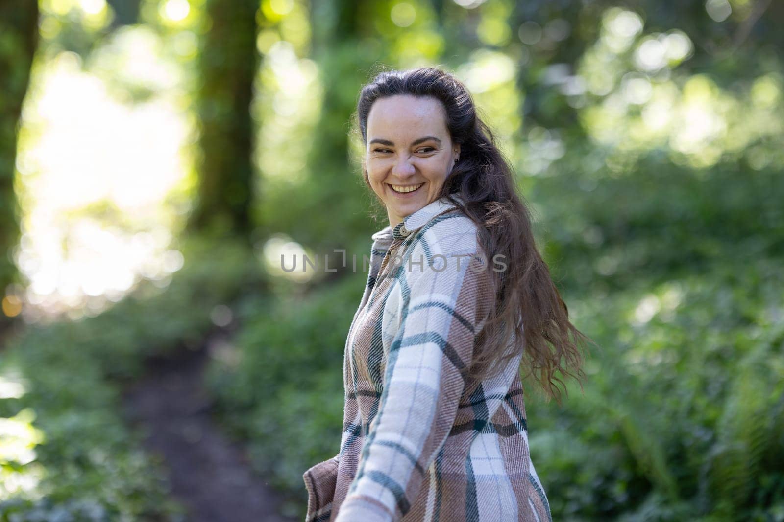Young Woman smiling and Walking Down Path in Woods by Studia72