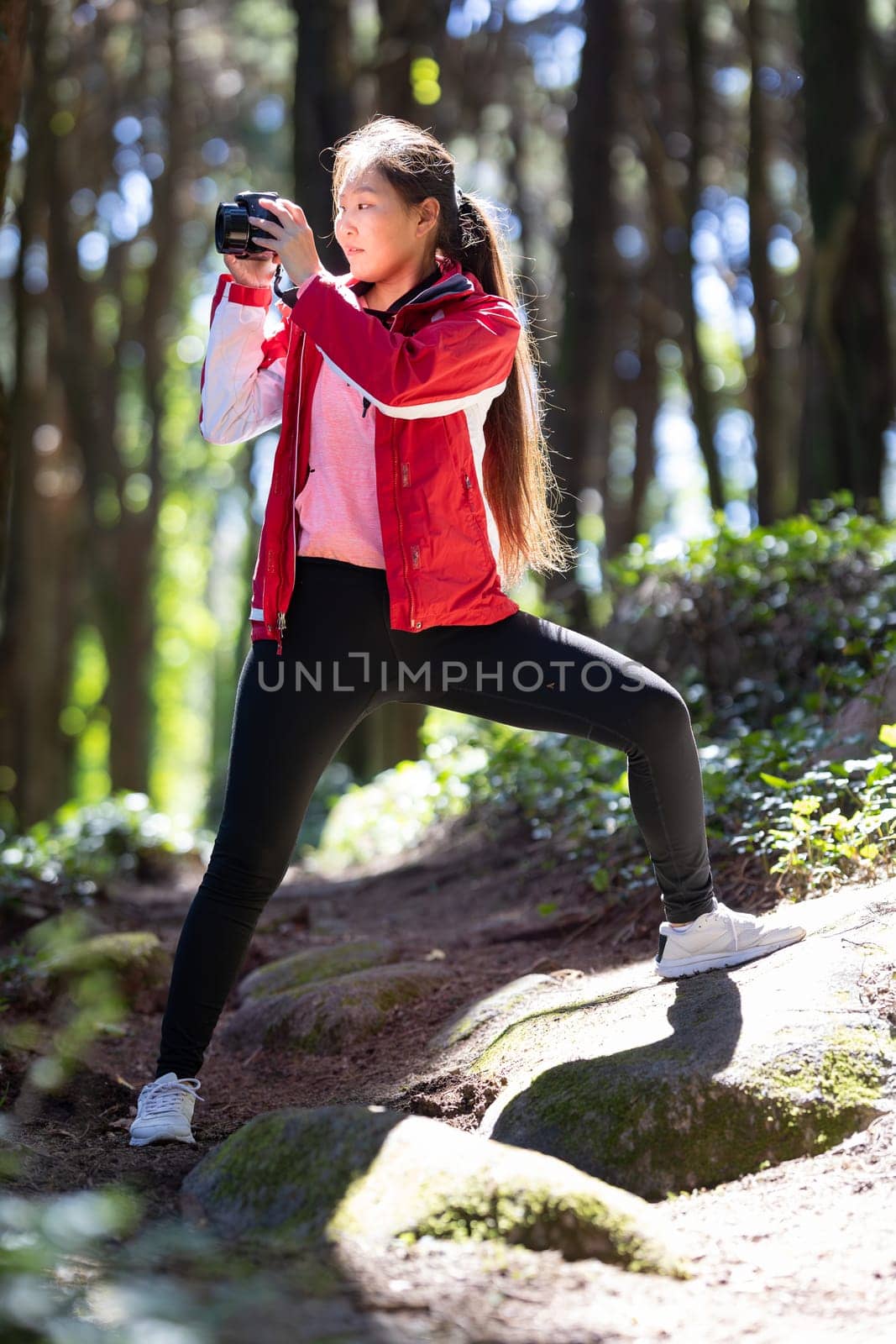 Woman photographer in Red Jacket Doing Yoga Pose by Studia72