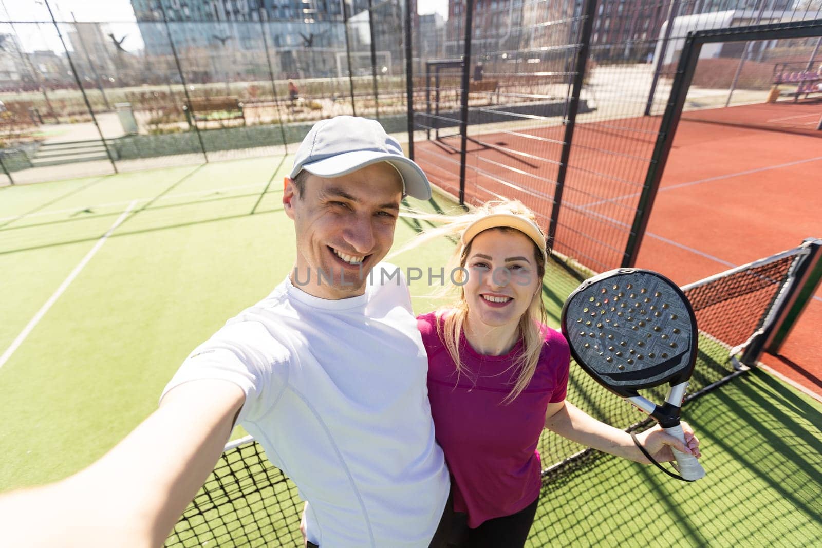 Paddle tennis woman and man team posing in wide angle image by Andelov13